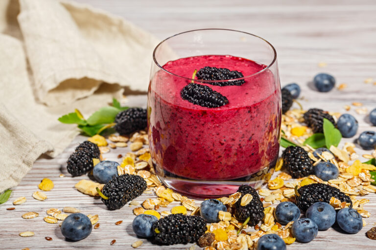 glass of smoothies, muesli and fresh berries